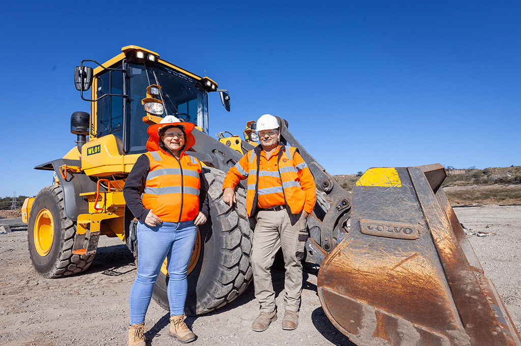 two people standing next to a volvo vehicle