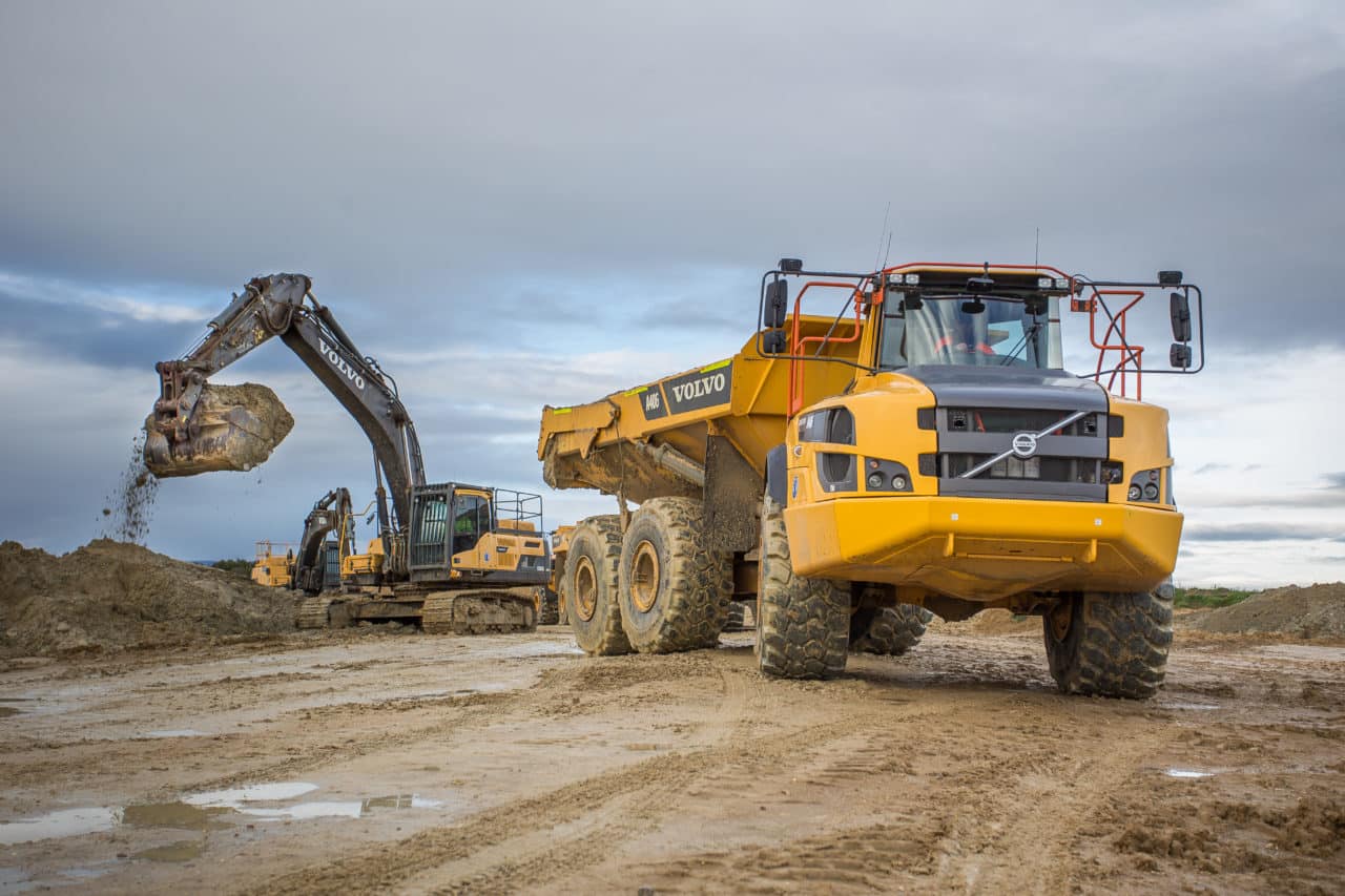 two volvo trucks at a worksite