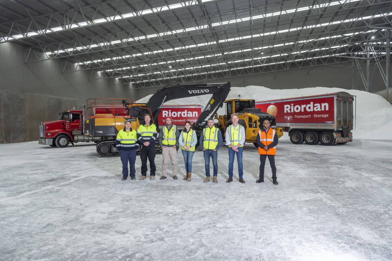 a team of people standing next to a lorry in a warehouse